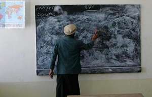 Teacher writing on a blackboard