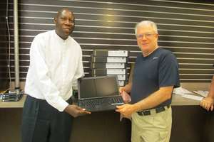 Receiving 10 laptops for the school from the donor