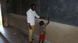 #3: A first grade student writing on black board