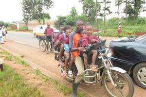 A motorcycle taxi transporting students