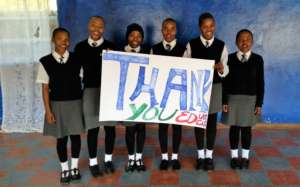 A group of smiling girls with a message of thanks.