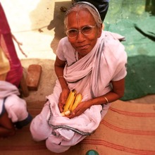 A widow smiles as she gets fruit after her meal