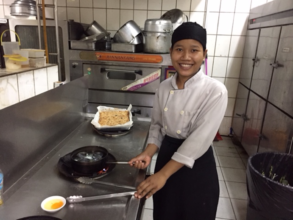 Somnang cooking at her job.