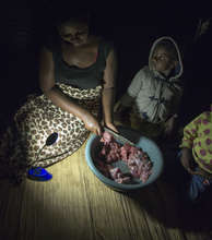 Annety cutting meat at night-time
