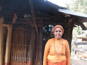 A lady in front of her hut.