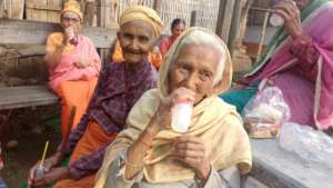An old women enjoying   Mango drink