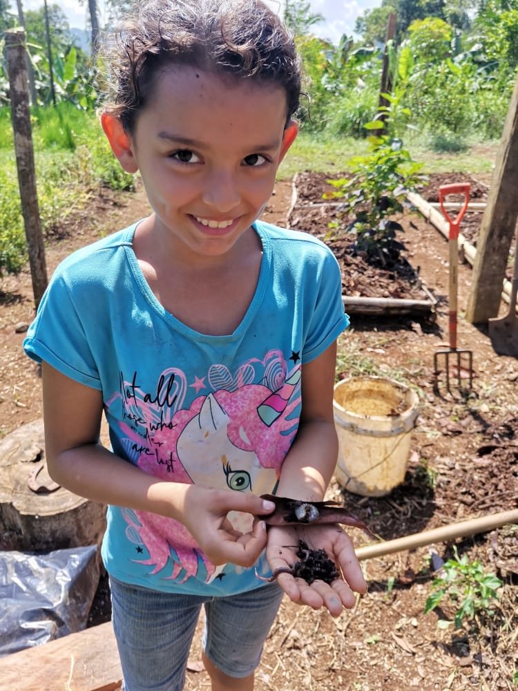 Children showing worms for compost