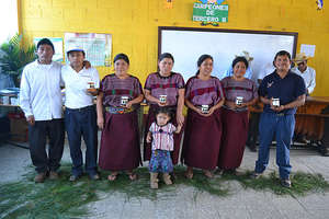 Members of the group pose with jars of honey