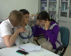 Mom listens to Hung's heart, pre-surgery