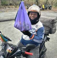 Smiling delivery rider with food pantry bag