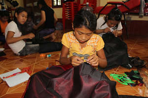 Tong learning to sew