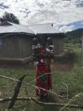 Mary with her twins in front of rescue home