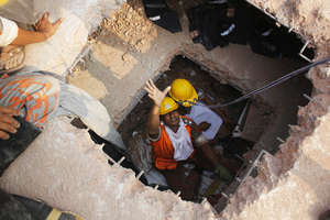 Rescuers working beneath layers of fallen floors