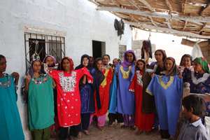 Khalida Brohi standing with women beneficiaries