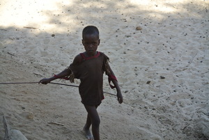 A young boy frolicking with a stick
