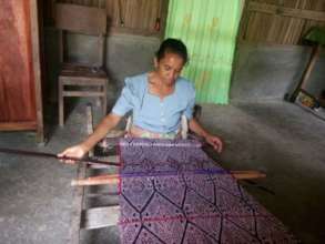 Yesthy's mother is weaving a scarf