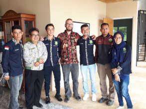 Refugees take a photo with staff and volunteer