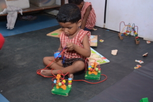 Child at our centre playing with beads stackers!