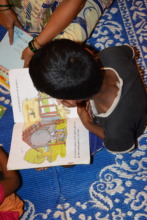 Child engrossed in reading at our centre