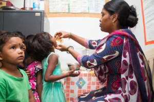 Teacher giving medicine to children