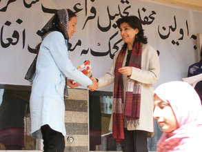 Hassina Sherjan in front of school