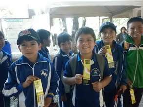 Kids from Pairumani Province holding postcards