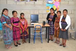Girls proudly display a  school computer