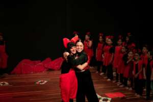 Teacher is congratulating  monitor for the concert