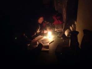 Doing their School homework with candle light.