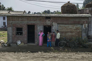 Manju and her family wave outside their home