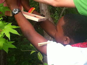 Adrian holding the box in place while Adam drills