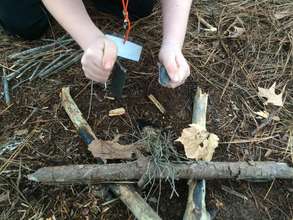 Attempting to start a fire with flint and steel