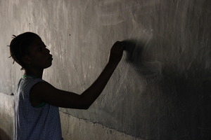 Girl writing on chalkboard in Guinea