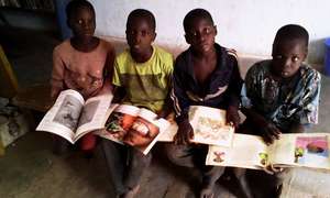 Reading children's books in Karaba library 2015