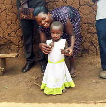 Little girl in Uganda w/ community health worker