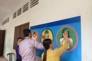 Volunteers and staff paint a road safety mural.