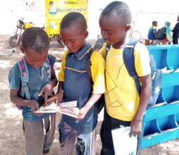 Kids examine a book, in October
