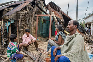 Basu Das and family in front of their damaged home