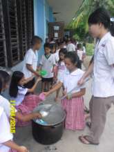 Children, teachers and parents serve lunch