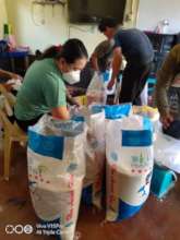Volunteers pack rice packets for families