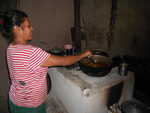 Isabel A. cooking on her improved cookstove