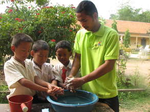 YS volunteer teaching children to wash their hands