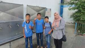 Ghada with school children next to a Maia unit