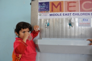A child at Ajial Kindergarten drinks clean water