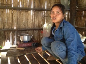 Mr. Rom using bio-gas to cook in her kitchen