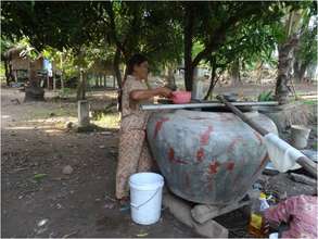 Mrs. Channy collecting wine rice for pig feed