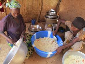 Women preparing couscous with vegetables