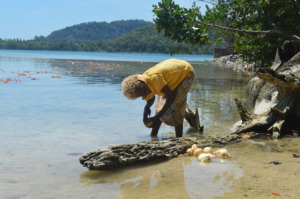 Girl use sea to clean sweet potatoe for lunch