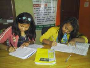 PRIYA,Class-7 and ANJU, Class-6 busy on homework.