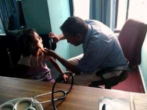Dr. Thakur is on medical checkup to children.